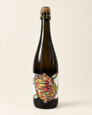 Crémant Entourloupe Zéro Dosage wine bottle, front label, warm cream studio background